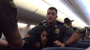 لحظة جر أفراد الشرطة للمرأة الحامل واخراجها من الطائرة- يوتيوب