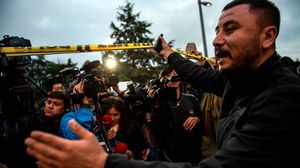 عنصر من الأمن التركي يبعد الصحفيين عن موقع عمل الخبراء الجنائيين- جيتي