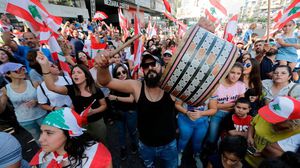 متظاهر يحمل طبلا للأفراح وسط المتظاهرين في العاصمة بيروت- جيتي