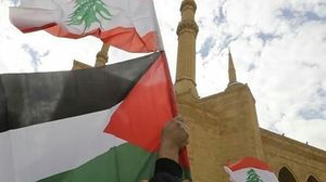 متظاهر يرفع علم فلسطين ولبنان في ساحة الشهداء وسط بيروت- تويتر
