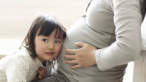 طفلة تتفقد نشاط الجنين في بطن والدتها