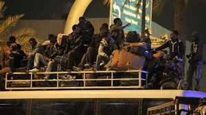 عمال أفارقة يجلسون على حافلة للشرطة قبيل نقلهم إلى مركز في الرياض - ا ف ب 