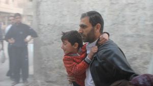 أب يهرب بأطفاله من القصف في حلب- ا ف ب