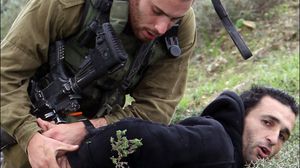جندي إسرائيلي يعتقل فلسطينياً (أرشيفية) - أ ف ب