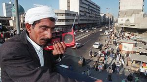 عراقي يستمع للراديو على جسر للمشاة في بغداد - أ ف ب  