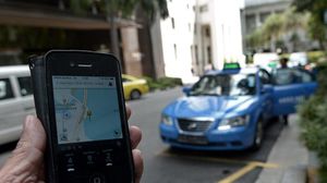 تطبيق "أوبر" وسيارة أجرة في الحي المالي في سنغافورة - أ ف ب