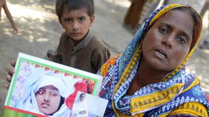 الباكستانية راضية شيخ تحمل صورة لابنتها - أ ف ب