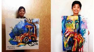 الطفل الفنان محمد قريقع مع إحدى لوحاته الخاصة - أرشيفية