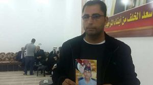 شقيق الضابط أنور أبو زيد يحمل صورته في ديوان العشيرة - تويتر