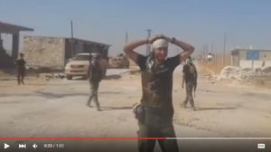 يظهر في الفيديو عناصر المليشيا العراقية وهم يتمازحون ويتشفون بجثة السوري - يوتيوب