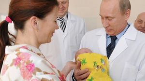 بوتين يحمل طفلة روسية بعد ولادتها - سبوتنيك