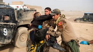 جنود عراقيون يساعدون زميلا لهم تمت إصابته برصاصة قناص في معارك الموصل- أ ف ب 