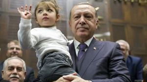 الطفلة عندما احتضنها الرئيس أردوغان ليتقط صورة معها بادرت برفع إشارة رابعة- تويتر