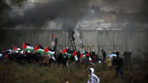فلسطينيون خلال مواجهات مع الاحتلال عند الجدار الفاصل- جيتي