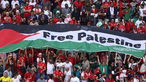 مشجعون يرفعون علم فلسطين مكتوب عليه "الحرية لفلسطين"- جيتي