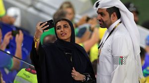 زوجان قطريان يرتديان شارة عليها علم فلسطين خلال مباراة للبرازيل أمس- جيتي