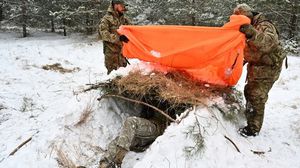 جنود أوكرانيون يحفرون خندقا وسط الثلوج- جيتي