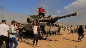 فلسطينيون فوق دبابة للاحتلال خلال عملية طوفان الأقصى- جيتي