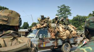 جنود تشاديون مشاركون في عملية سانغاري في أفريقيا الوسطى يمرون بسيارتهم امام جنود فرنسيين الجمعة (أ ف ب)