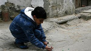 طفل فلسطيني يلعب "البنانير" في أحد الأحياء في نابلس - أرشيفية