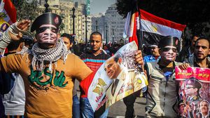 انصار السيسي يلبسون قناعا على شكل وجهه في التحرير - الاناضول