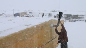 يكافح اللاجئون السوريون لحماية أنفسهم من برد الشتاء وحصاره - أ ف ب