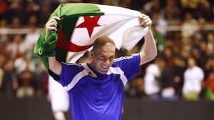 زيدان مدرب ريال مدريد يحمل علم بلده الأصلي الجزائر - غوغل