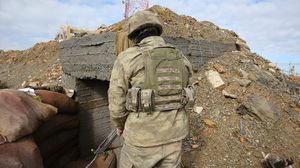 جندي تركي أمام خندق محصن أنشأته الوحدات الكردية بجبل برصايا- الأناضول