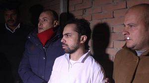 الصحفي المعتقل شادي أبو زيد خلال حضوره مراسم دفن والده وهو يرتدي ثياب السجن البيضاء- فيسبوك