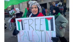ناشطة في كندا ترفع لافتة مع أعلام فلسطين- تويتر