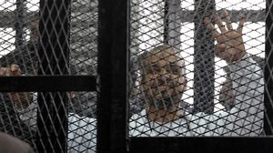 محمد البلتاجي يرفع شعار رابعة خلال جلسة محاكمته يوم الأربعاء (الأناضول)