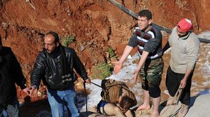 سوريون يسحبون جثة من قناة مائية بعد قيام قوات النظام باعتداءات في إدلب - ا ف ب