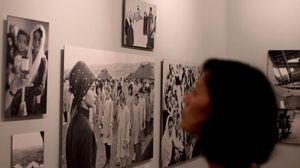 زائرة تتأمل صورا في معرض للأونروا في مركز المعمل في القدس - ا ف ب