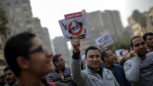 متظاهر يرفع لافتة لمقاطعة الاستفتاء على دستور "الإنقلاب" - الاناضول