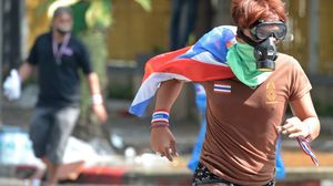 متظاهرون يتحدون الشرطة التايلندية بعد اطلاقهم غازا مسيلا للدموع - ا ف ب 