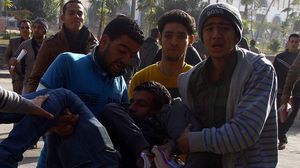 طلاب في جامعة الأزهر ينقلون زميلا لهم أصيب خلال اقتحام الأمن للجامعة الأحد (الأناضول)