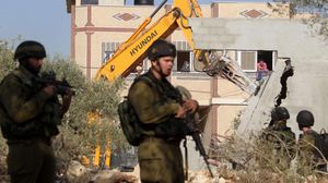 آلية إسرائيلية بحراسة جنود إسرائيليين تهدم أحد المنازل بالقدس - أرشيفية