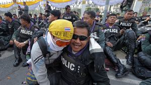 محتج يحتضن شرطيا خلال الاحتجاجات الثلاثاء - ا ف ب 