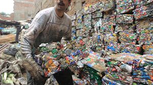 أحد الفقراء في منطقة الزبالين في المقطم  (القاهرة) يقوم بجمع النفايات التي يمكن تدويرها - أ ف ب