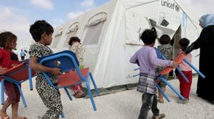 أطفال سوريين في مخيم الزعتري في طريقهم الى خيمة الدراسة - أ ف ب