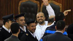 محمد البلتاجي رافعاً شعار "رابعة" خلال إحدى المحاكمات - أرشيفية