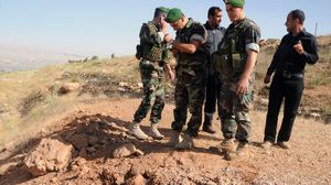 جنود لبنانيون يتفقدون آثار سقوط صاروخ في عرسال - ا ف ب