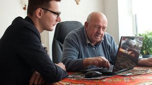 طالب يقوم بتعليم عجوز كيفية استخدام الحاسوب في دار رعاية - أ ف ب