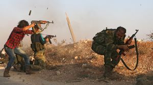 مقاتلون في الجيش السوري الحر خلال إحدى المعارك مع قوات النظام السوري مدعومة بالمليشيات- أ ف ب 