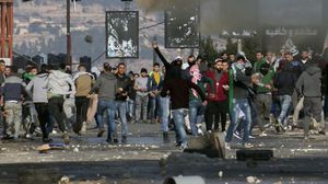 شبان فلسطينيون يرشقون قوات الاحتلال بالحجارة على إحدى نقاط التماس قرب رام الله- جيتي