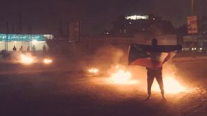 شاب سوداني يرفع علم بلاده خلال التظاهرات ضد الأوضاع الاقتصادية- تويتر