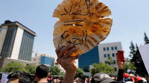 مواطن أردني يرفع رغيف خبز خلال تظاهرة في العاصمة عمان- جيتي