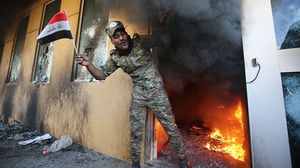 عنصر من الحشد الشعبي أثناء اقتحام عشرات المحتجين حرم السفارة الأمريكية بغداد وإضرام النيران في بوابتين وأبراج للمراقبة- جيتي