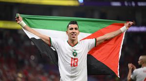 لاعب منتخب المغرب يحمل علم فلسطين في أثناء الاحتفال بالتأهل للدور الثاني بكأس العالم