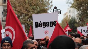 تونسيون يرفعون لافتة كتب عليها ارحل بالفرنسية- جيتي